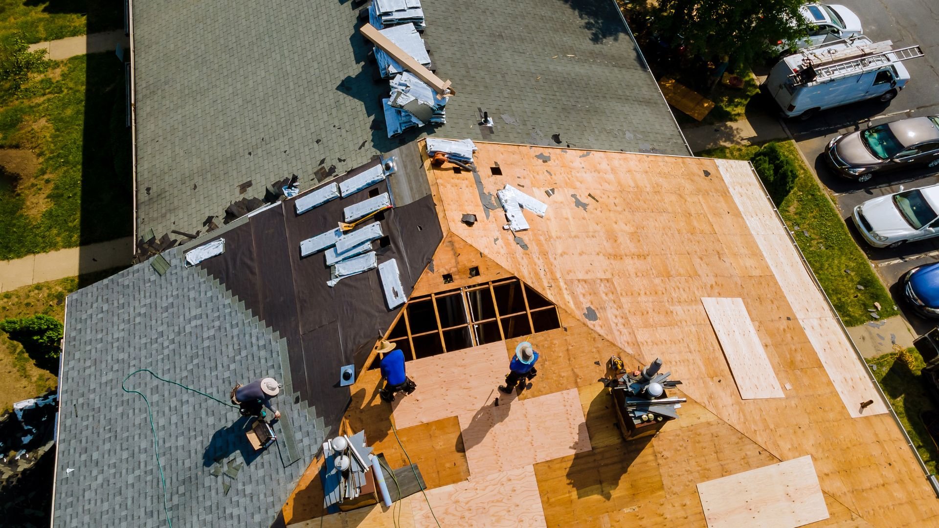 Aerial view of roofers working on a house with wooden and shingle roof sections