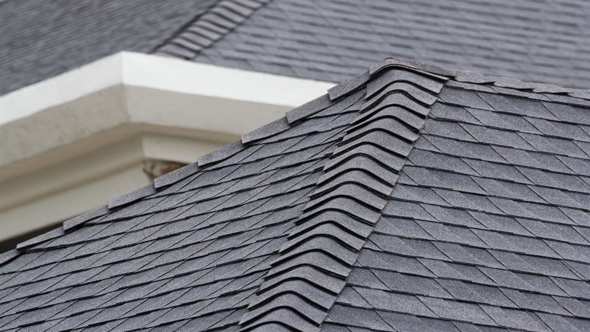 Gray shingle roof with overlapping layers and white architectural detail
