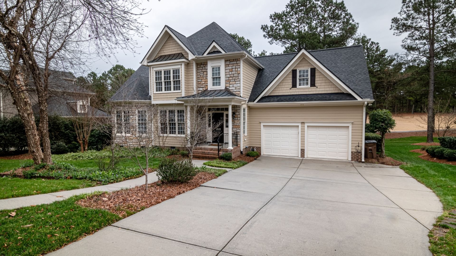 Two-story suburban house with stone and siding exterior and double garage